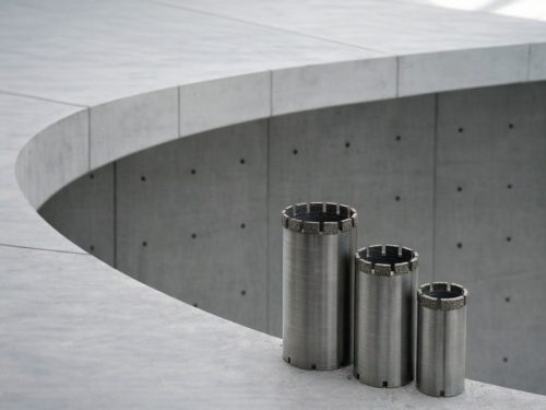 Tre diamantkjernebor i ulike størrelser plassert på en betongoverflate.